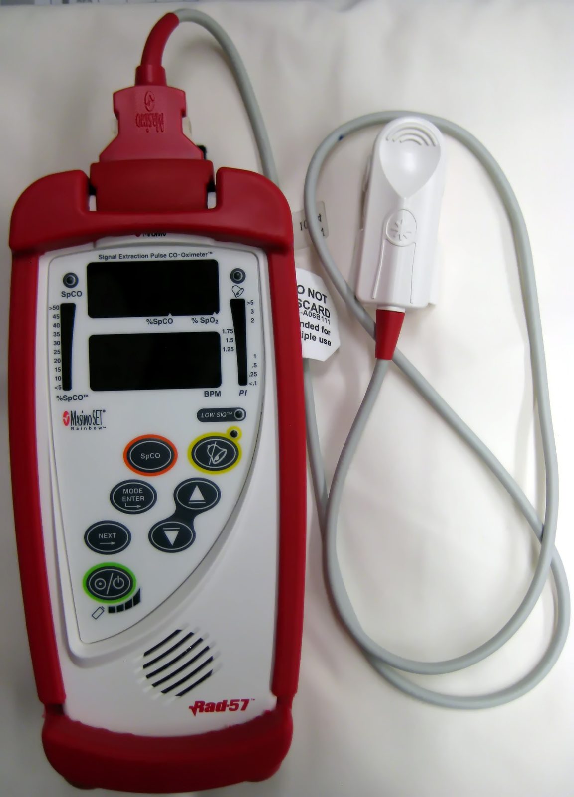 A pulse CO-oximeter with a finger probe measures carboxyhaemoglobin separately from oxygen saturation; conventional pulse oximetry cannot reliably distinguish carboxyhaemoglobin from oxyhaemoglobin and can appear falsely reassuring.