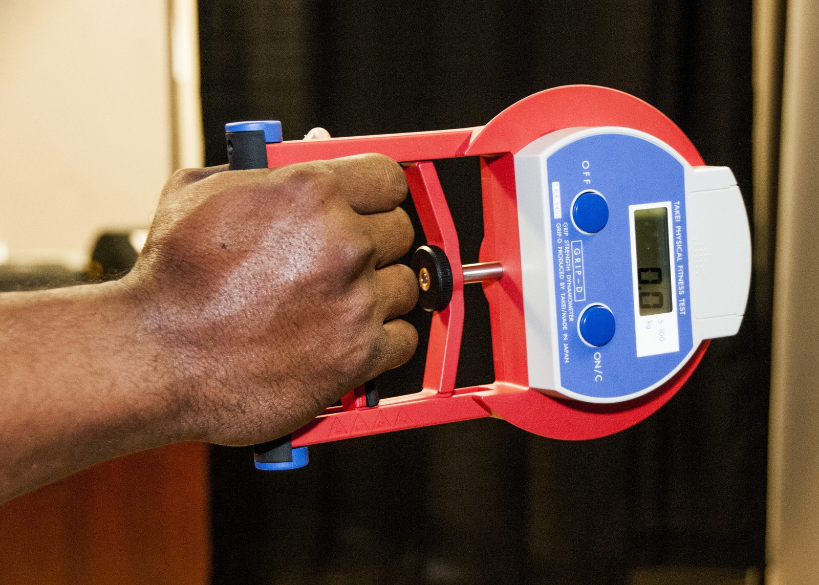 Hand-grip strength being measured with a calibrated dynamometer; low strength identifies probable sarcopenia before confirmation with muscle quantity or quality assessment.